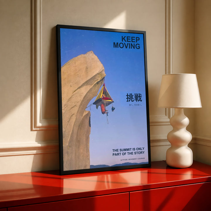 Framed motivational poster on table with blue cliff scene, rock climber and "Keep Moving"