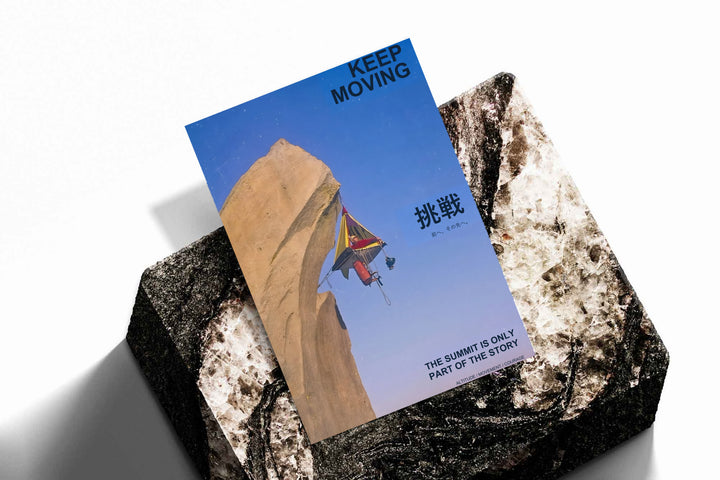 Motivational poster lying on textured rocks, blue cliff scene with rock climber