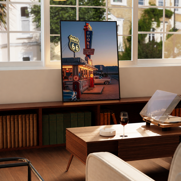 Route 66 Diner Poster in a black frame near a window and wooden table in a sunlit sitting room.