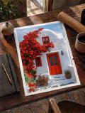 Santorini doorway print on table with white border, red doors, windows, and flowering tree