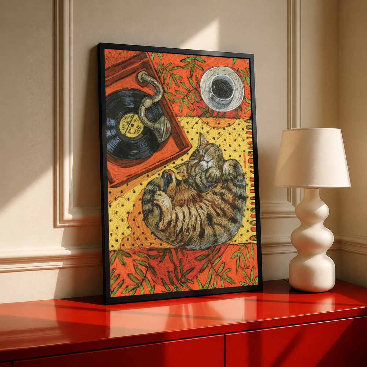 Cat sleeping on vinyl art print, warm orange collage in black frame on red cabinet