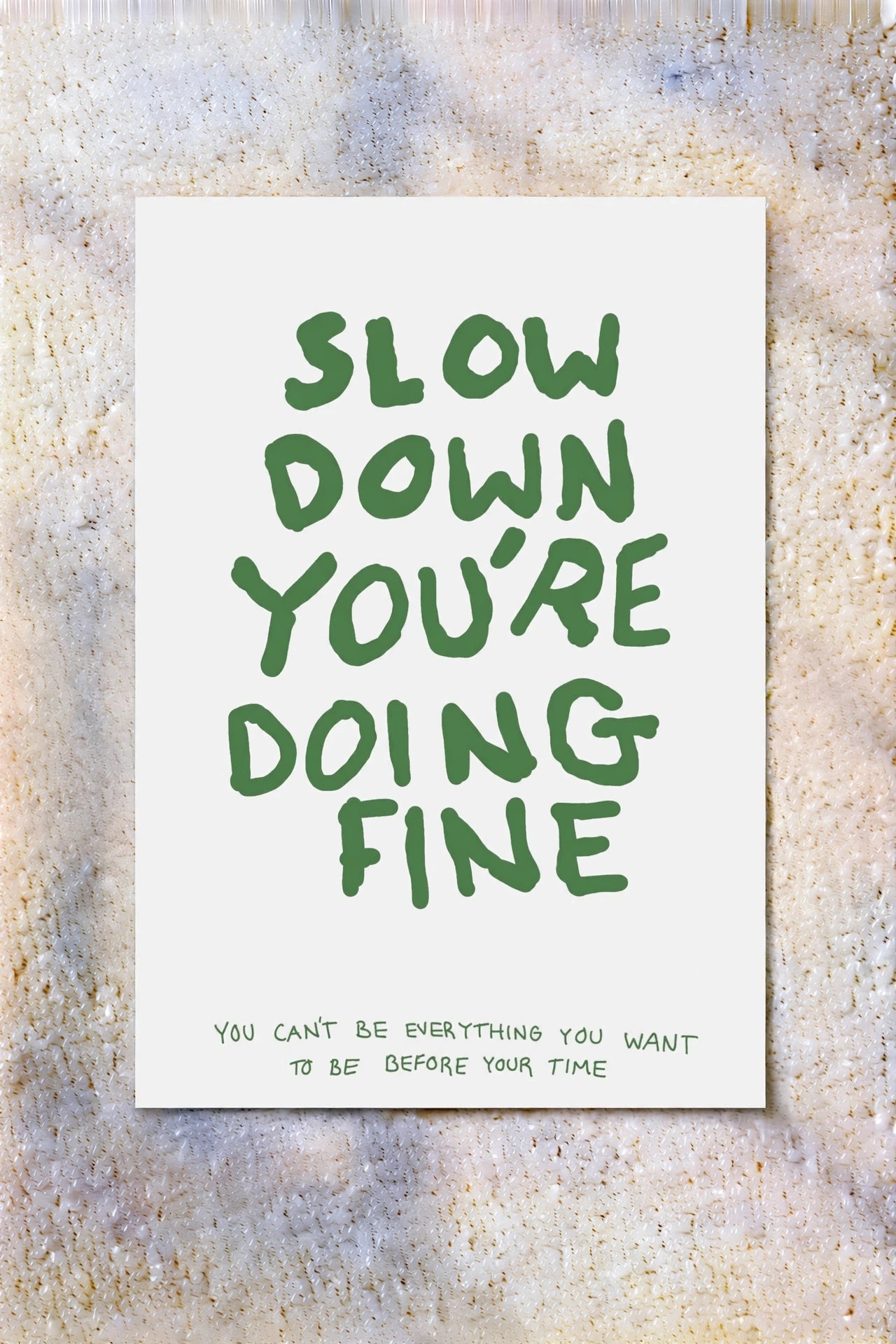 White poster with green 'Slow Down You're Doing Fine' quote text