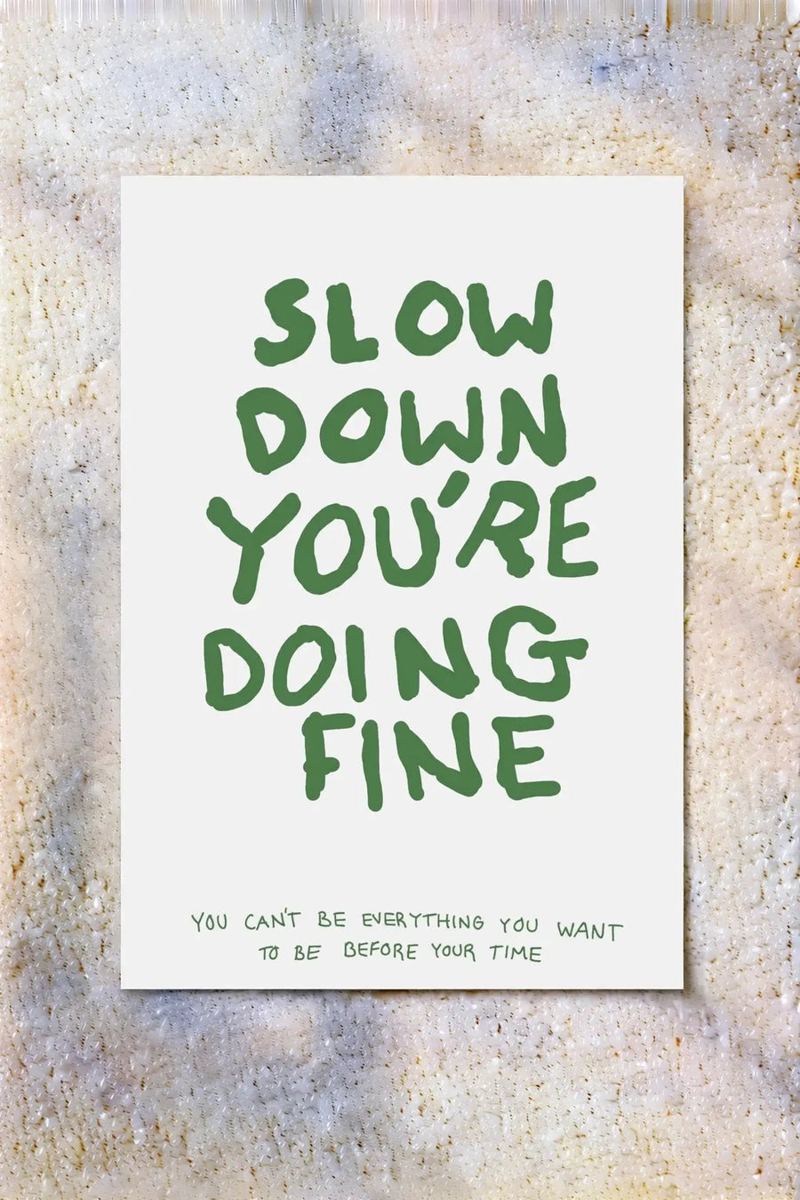 White poster with green 'Slow Down You're Doing Fine' quote text