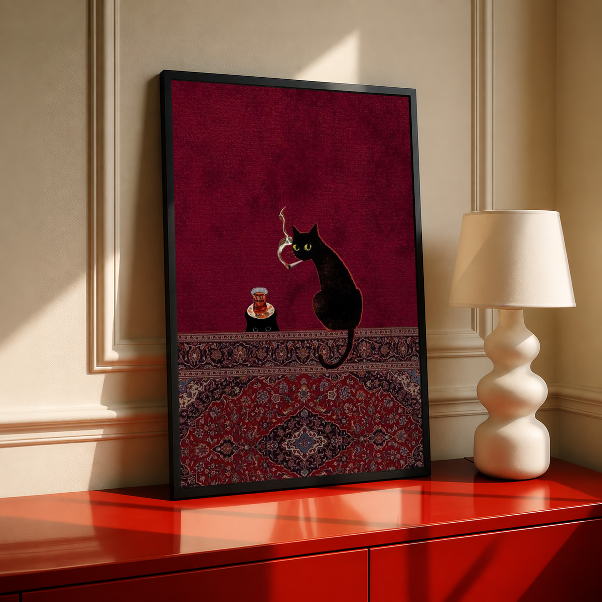 Framed wall art with black frame, burgundy cat scene, tea cup, and ornate rug border