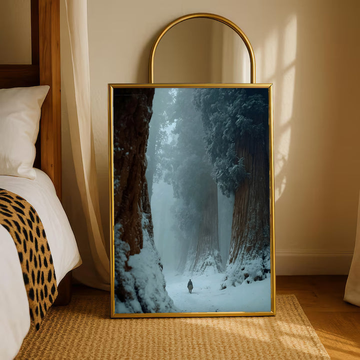 Gold-framed winter forest print with snowy path and small figure between trees