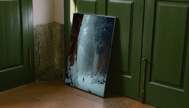 Winter forest print with dark frame, featuring snowy path and distant walker