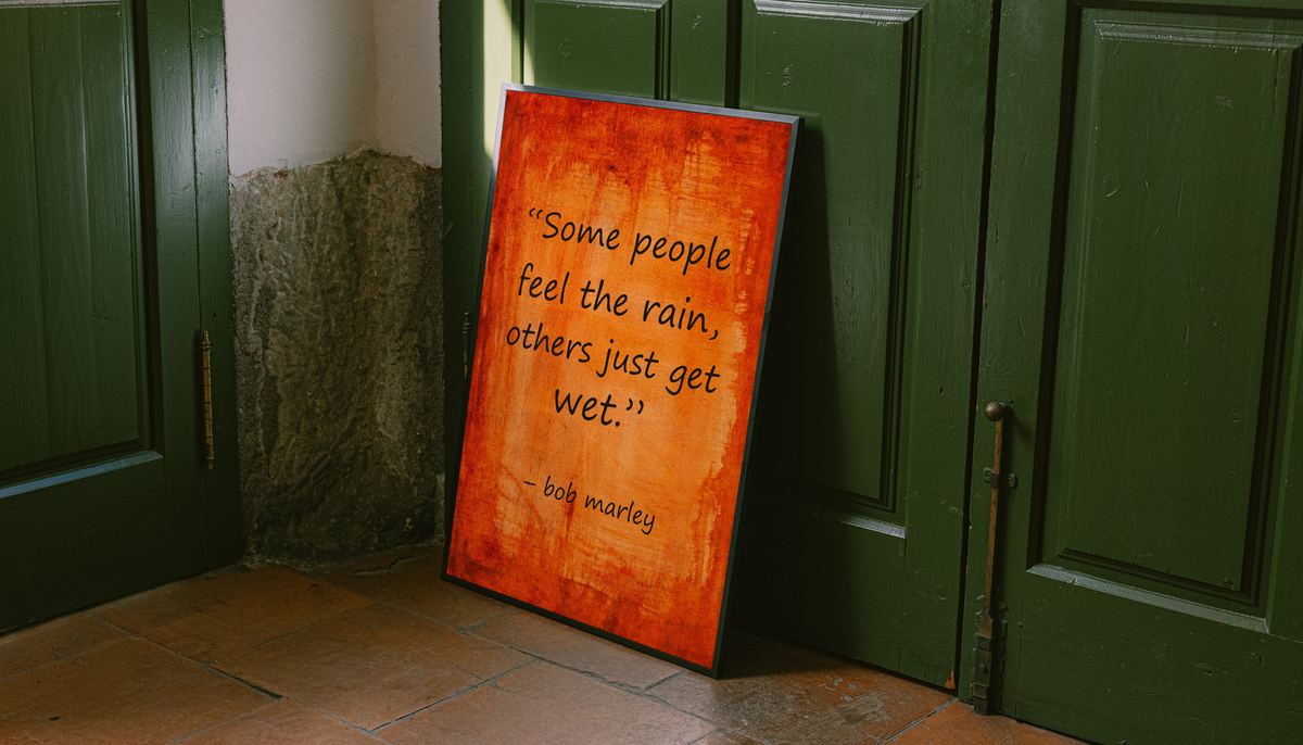 Framed quote poster on orange textured background leaning against green doors