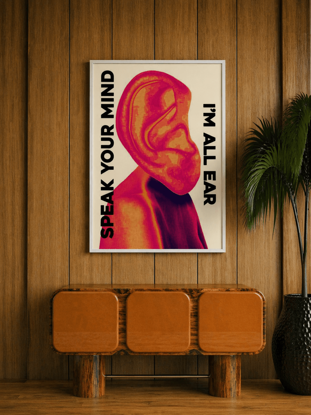 Quadro da parete incorniciato con illustrazione di un orecchio rosa con "SPEAK YOUR MIND" e "I'M ALL EARS"