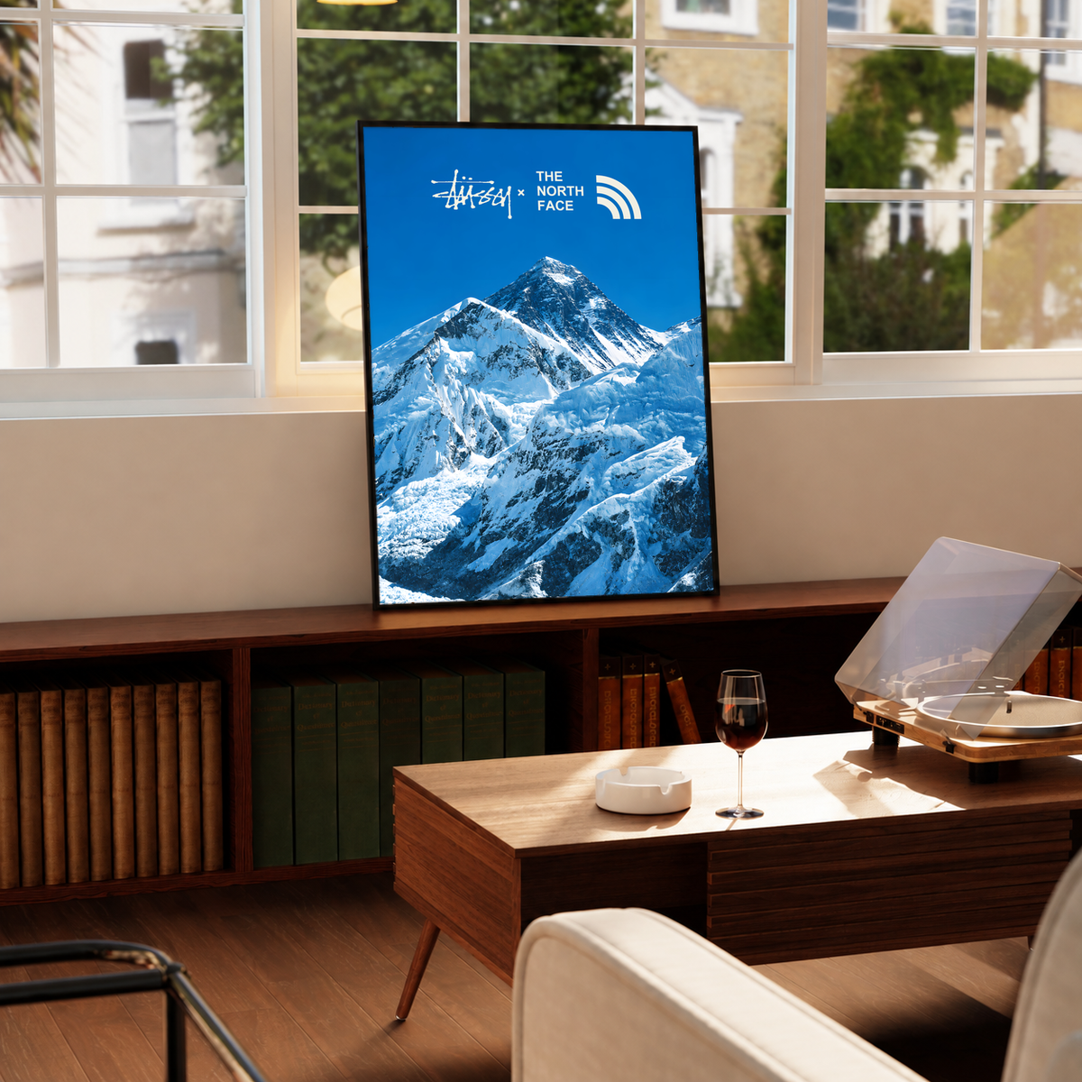 Blue snowy mountain landscape with Stussy and The North Face marks; framed print beside a window