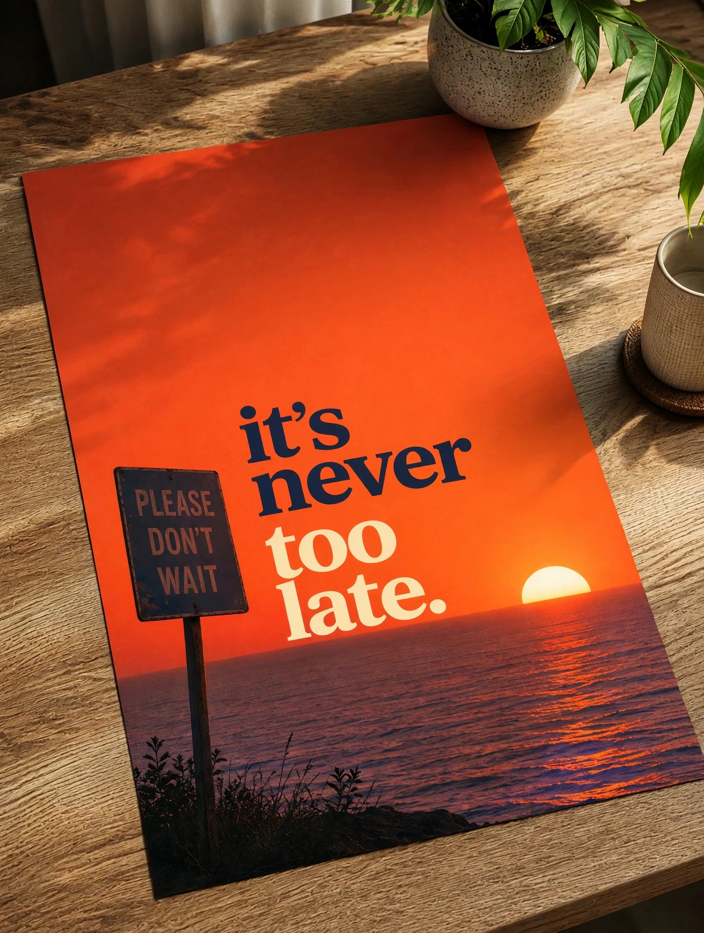 Motivational paper poster on wood surface, orange sunset with “it’s never too late” text.
