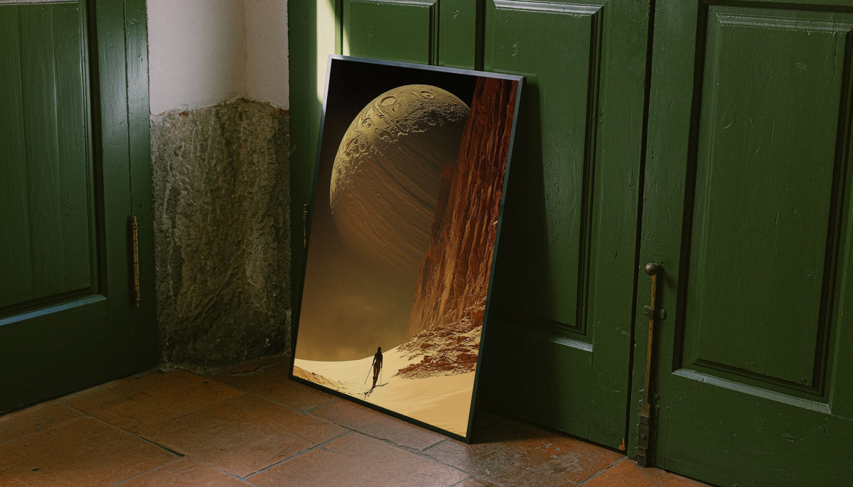Framed desert planet poster with planet sphere, sandy incline, and lone traveler by cliff.