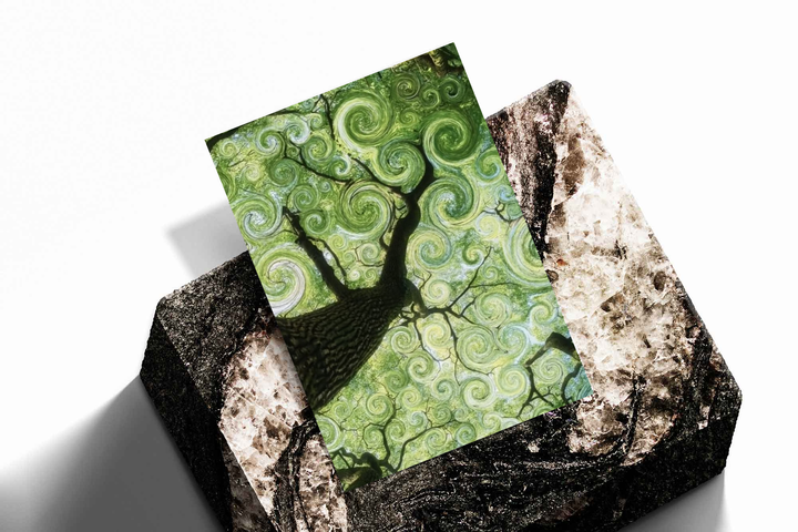 Swirling green tree canopy as an unframed print propped against a pale wall on a rough stone