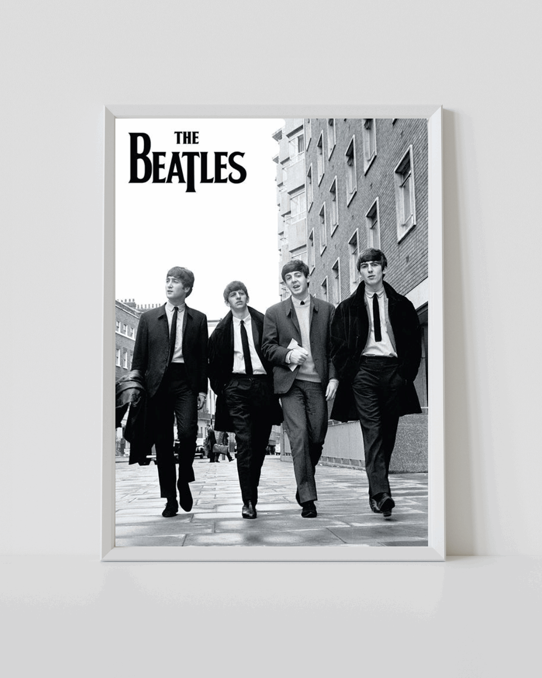 The Beatles black-and-white music poster featuring band walking, in a white frame