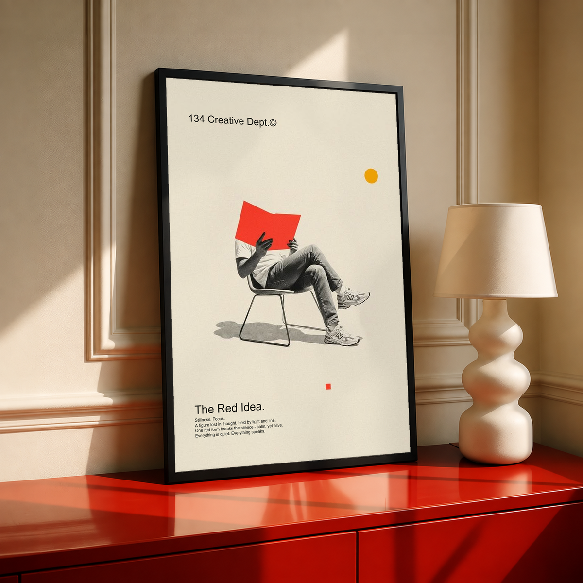Framed collage poster on cream backing with red chair figure, black frame