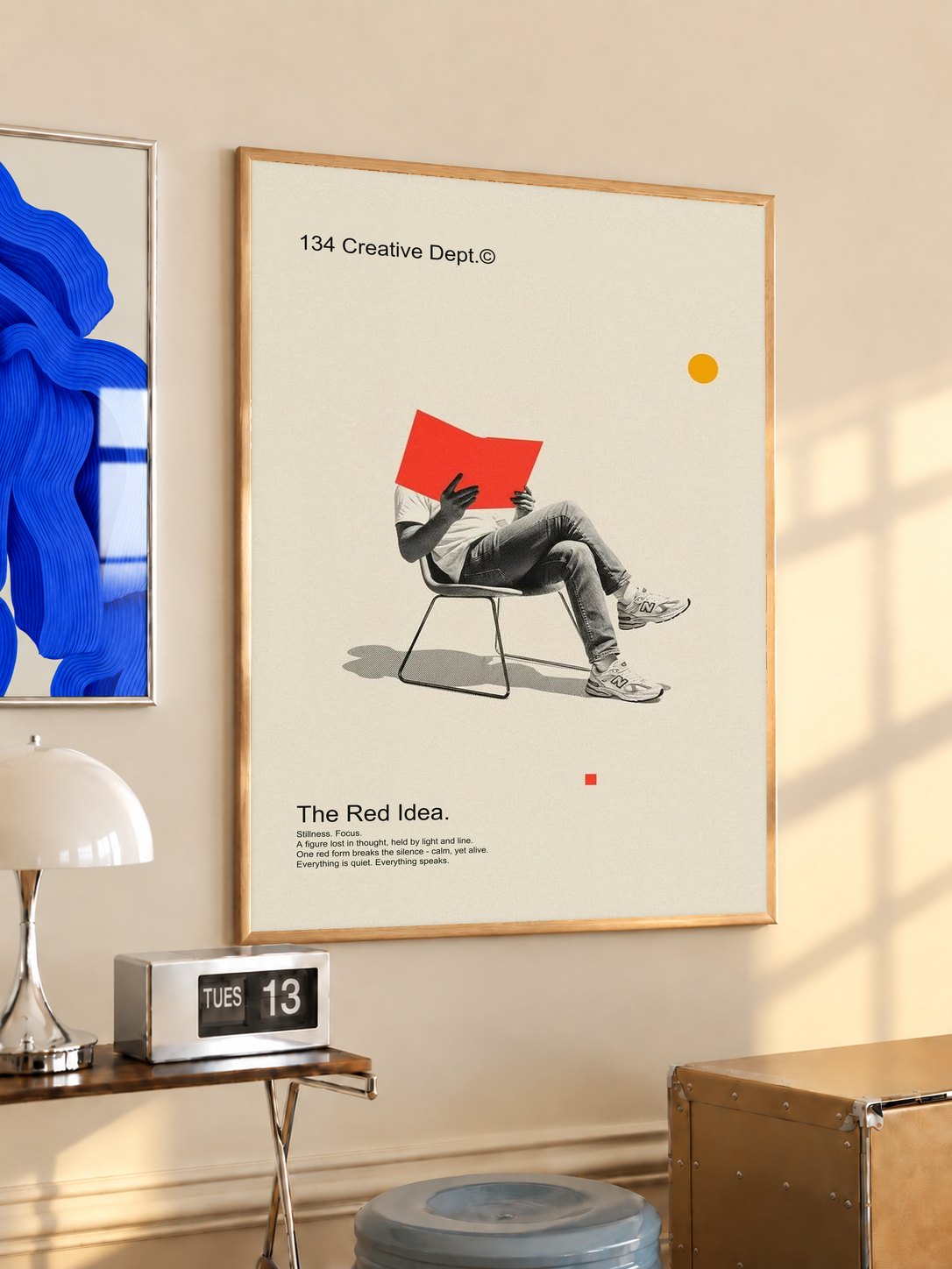 Framed collage poster with cream background, red chair artwork, wood frame