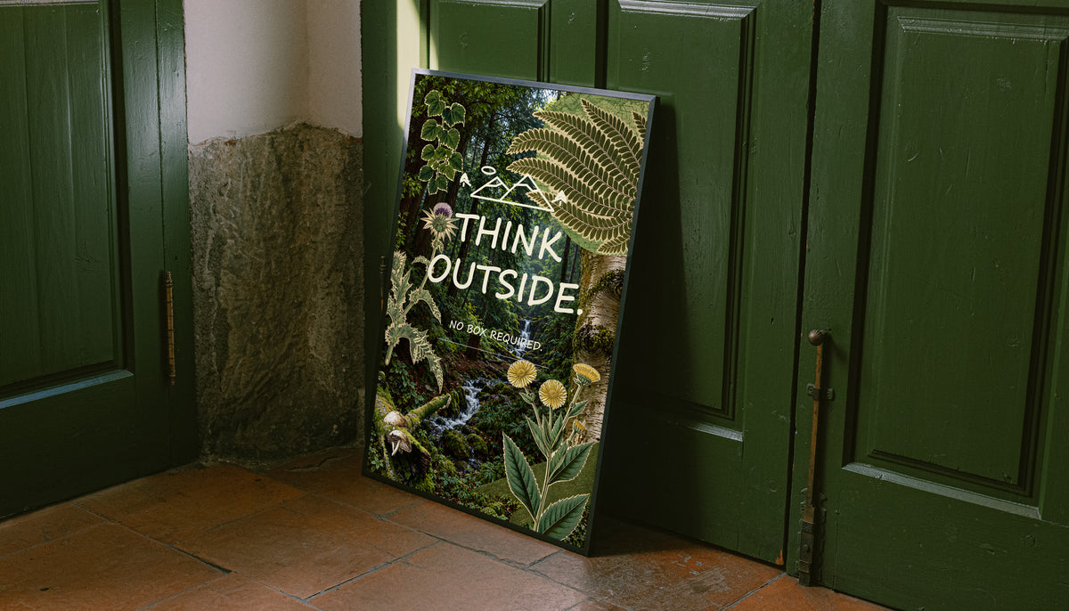 Botanical poster leaning against a door, printed with ferns, wildflowers and a forest stream.