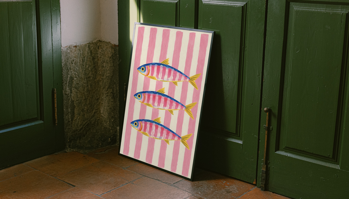 Framed wall art print with three colorful fish on pink vertical stripes