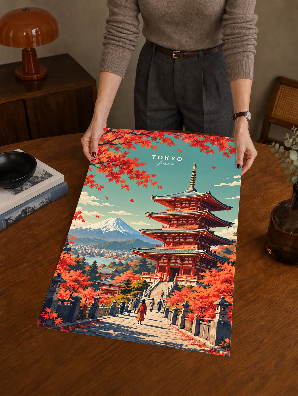 Person holding a Tokyo art poster with pagoda, red maple leaves and Mount Fuji