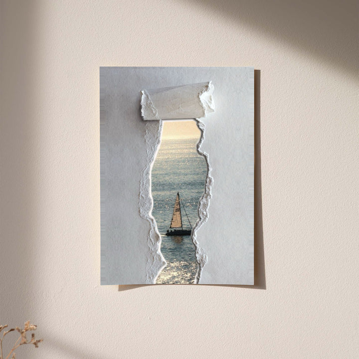 A sailboat at sea seen through a printed torn-paper opening on a grey ground displayed without a visible frame on a softly lit pale wall