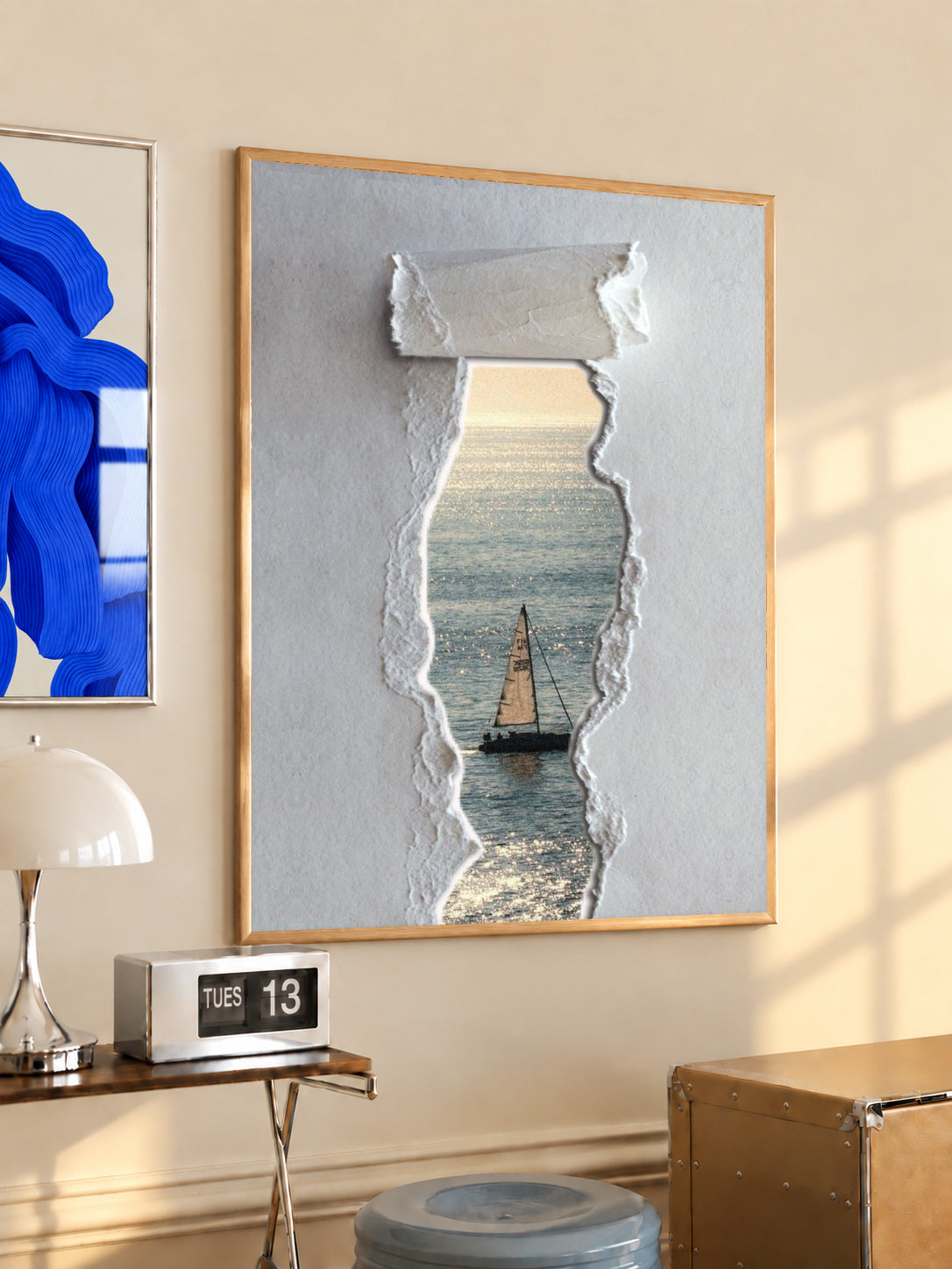 Framed torn-paper ocean sailboat wall print with grey textured paper and light wood frame.