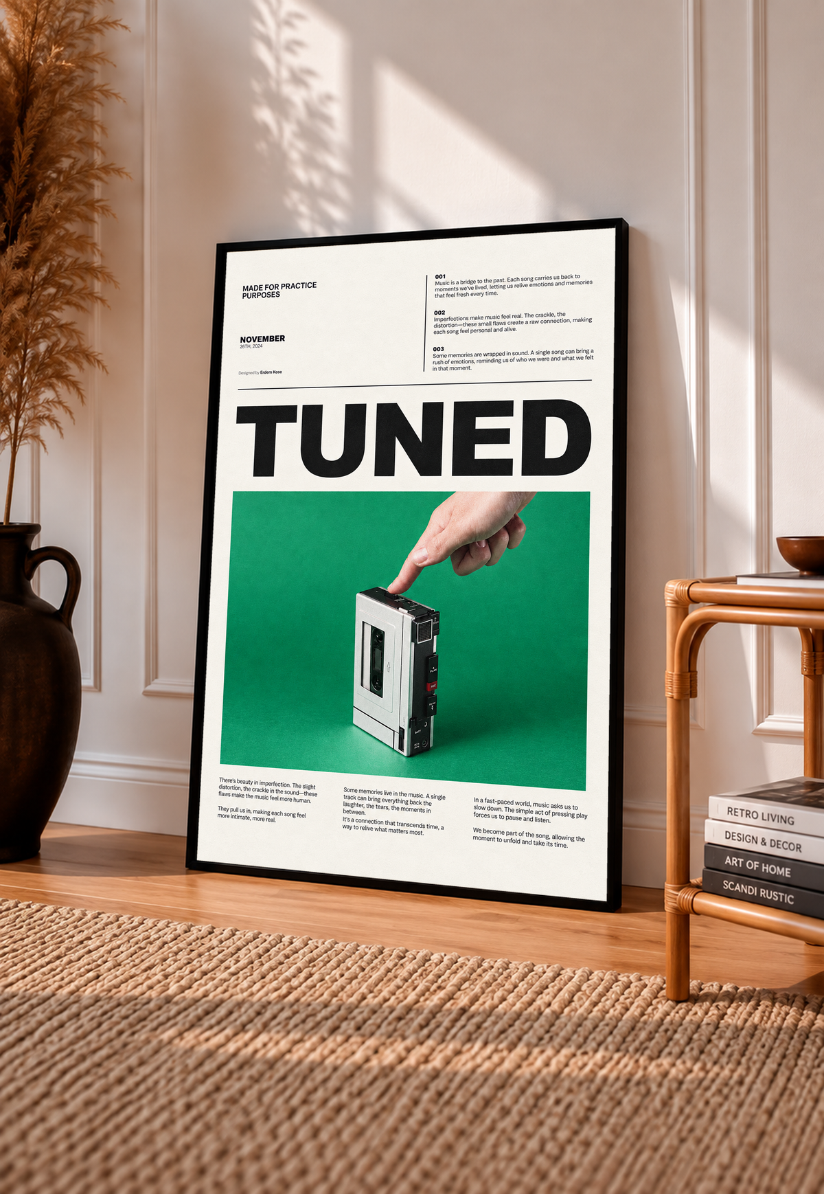 A hand pressing a portable cassette player against green beneath Tuned typography in a black frame leaning on a sunlit floor beside a rattan chair