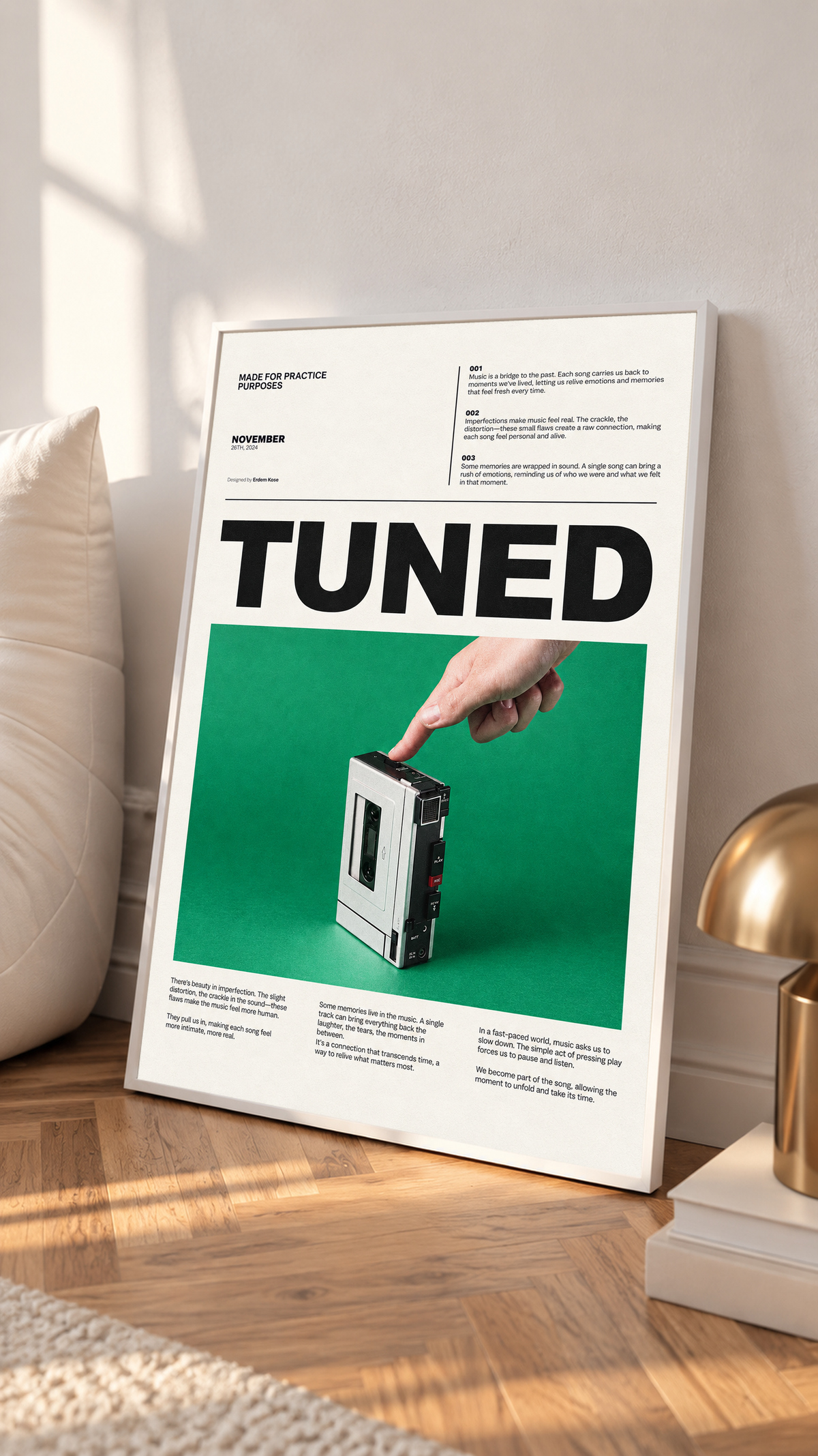 A hand pressing a portable cassette player against green beneath Tuned typography in a white frame on a sunlit floor beside a white cabinet