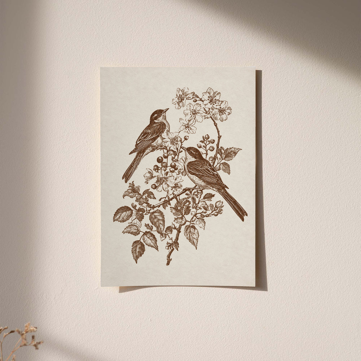 Two birds perched on a flowering branch with leaves and blossoms in sepia as an unframed hanging paper print against a plaster wall