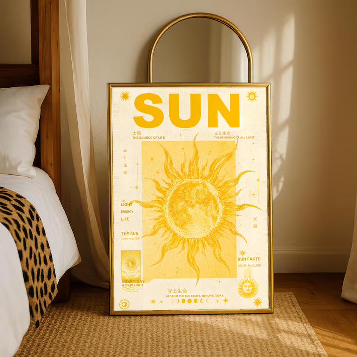 Sun typography and solar illustration in a warm wood frame on a bedroom floor beneath an arched mirror