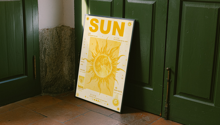Sun typography and solar illustration as an unframed display leaning against a green paneled door on a wood floor