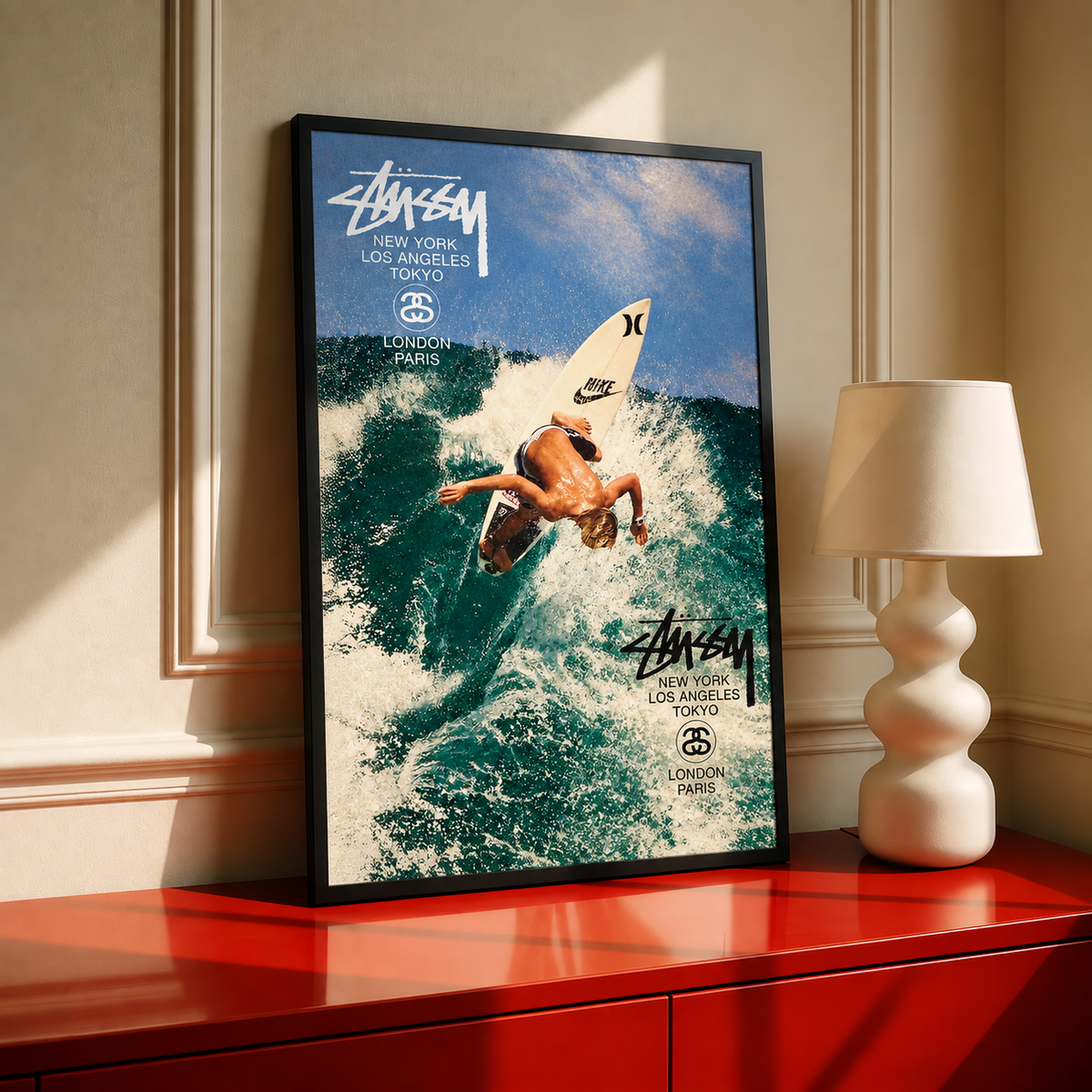 Framed vintage surf wall art with surfer on board and repeated Stussy logos over ocean waves