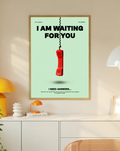 A suspended red telephone receiver and Waiting for You lettering on mint green in a slim oak frame on a cream wall above a white cabinet