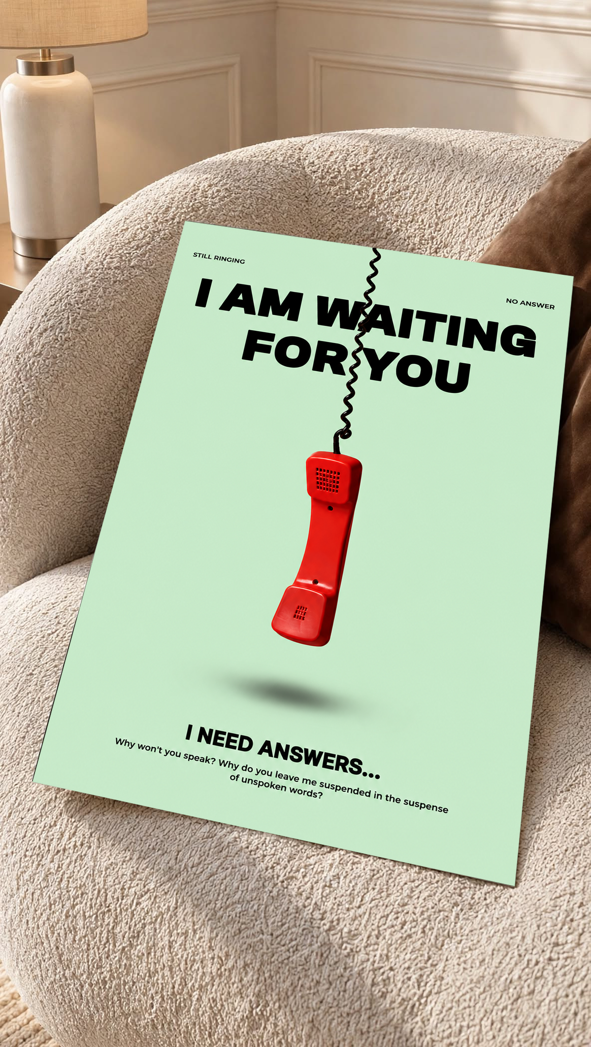 A suspended red telephone receiver and Waiting for You lettering on mint green as an unframed poster resting on a cream woven chair