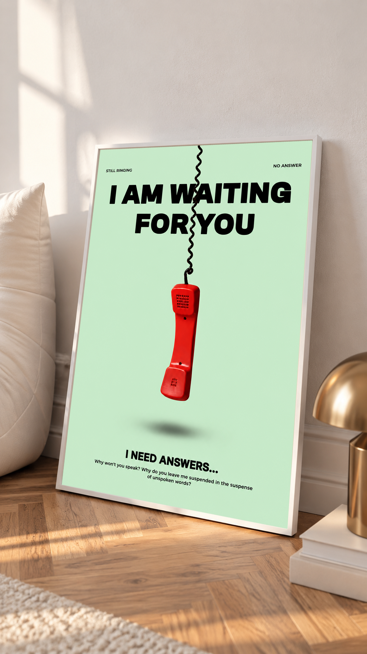 A suspended red telephone receiver and Waiting for You lettering on mint green in a white frame on a sunlit floor beside a white cabinet