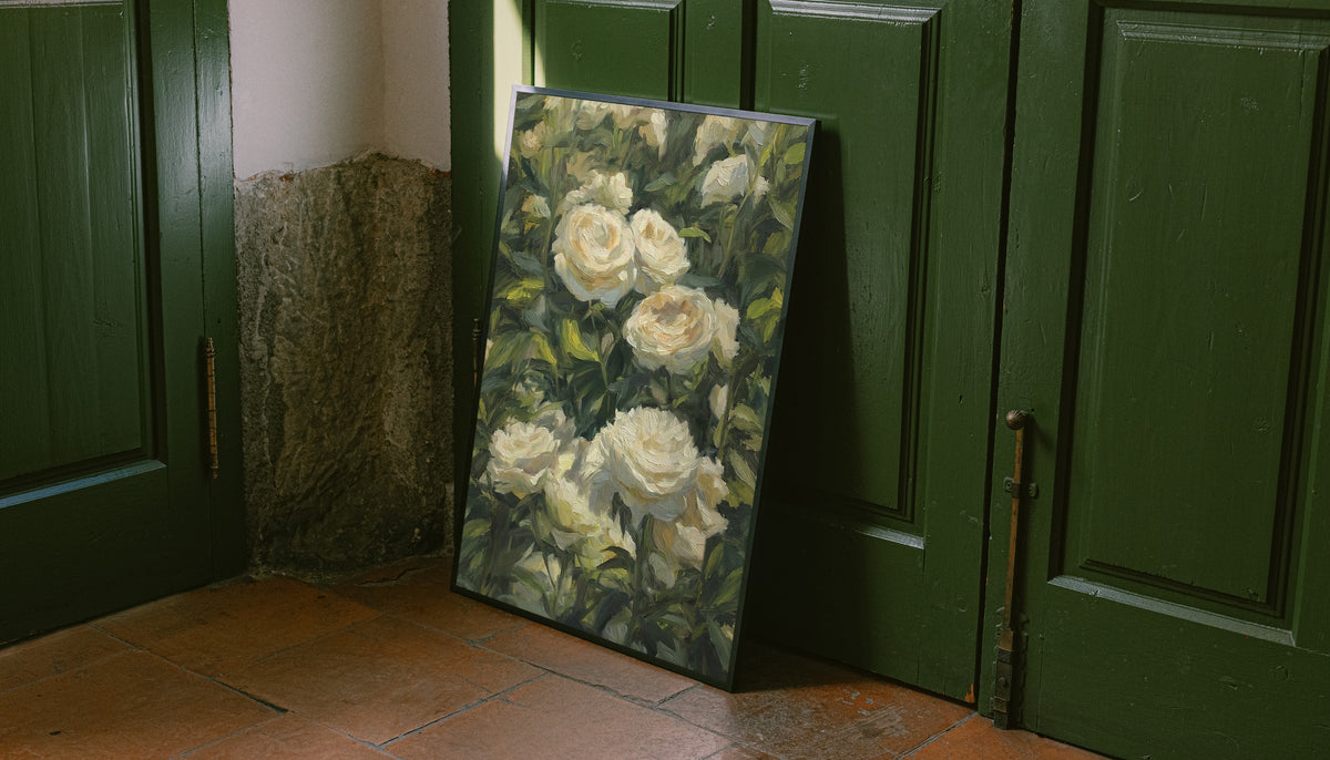 Cream white roses among dense green garden foliage in a painterly composition as an unframed print leaning against a green panelled door