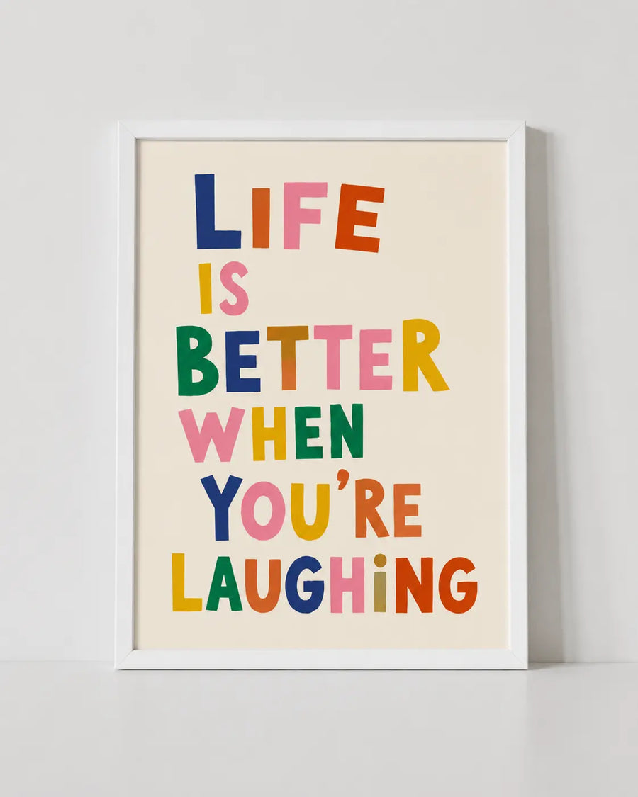 Weiß gerahmtes Typografie-Poster mit dem Text „DAS LEBEN IST SCHÖNER, WENN DU LACHST“