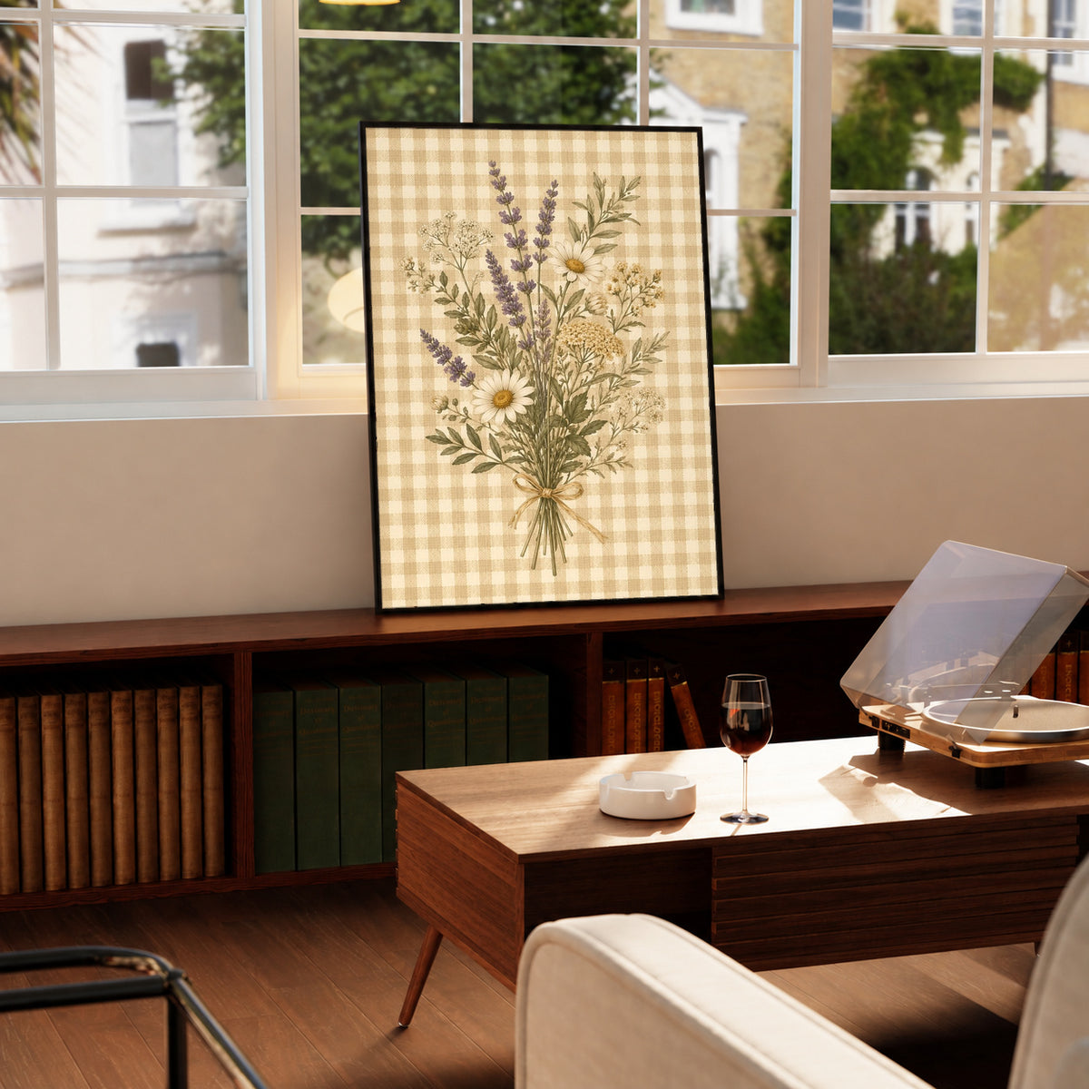 Tied bouquet of daisies lavender toned sprigs and white wildflowers on beige gingham in a black frame on a wooden cabinet beside a window and record player