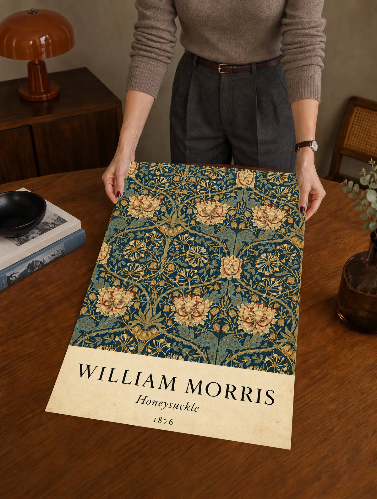 William Morris Honeysuckle floral pattern with gold and pink blooms on dark teal as an unframed print held over a wooden table beside a record player