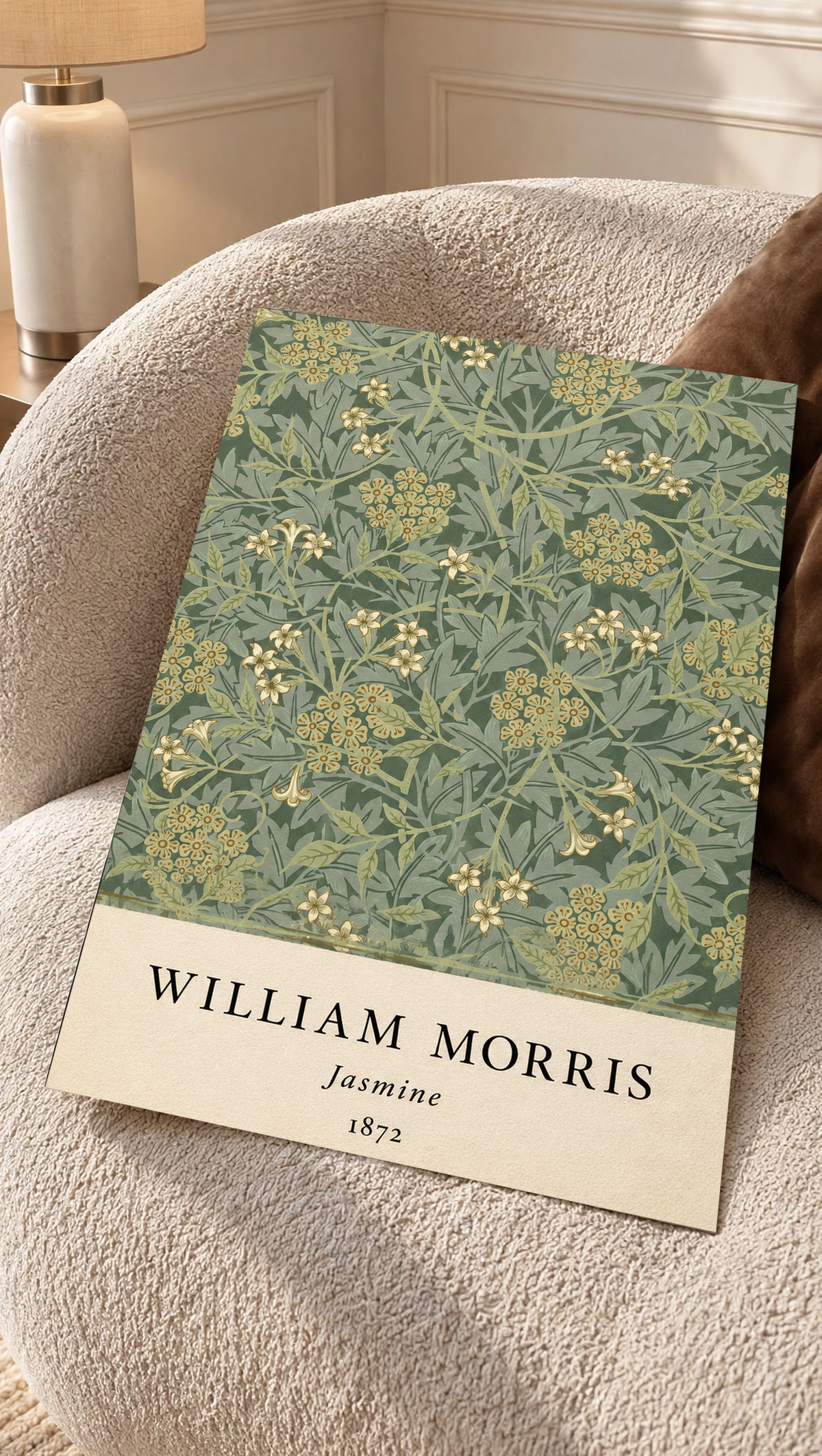 William Morris Jasmine sage and olive foliage with pale yellow flowers as an unframed print resting on a boucle chair