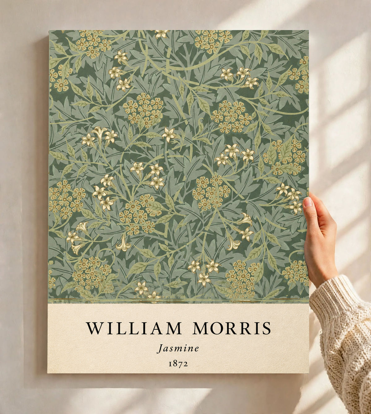 William Morris Jasmine sage and olive foliage with pale yellow flowers as an unframed print held against a pale wall in a close view