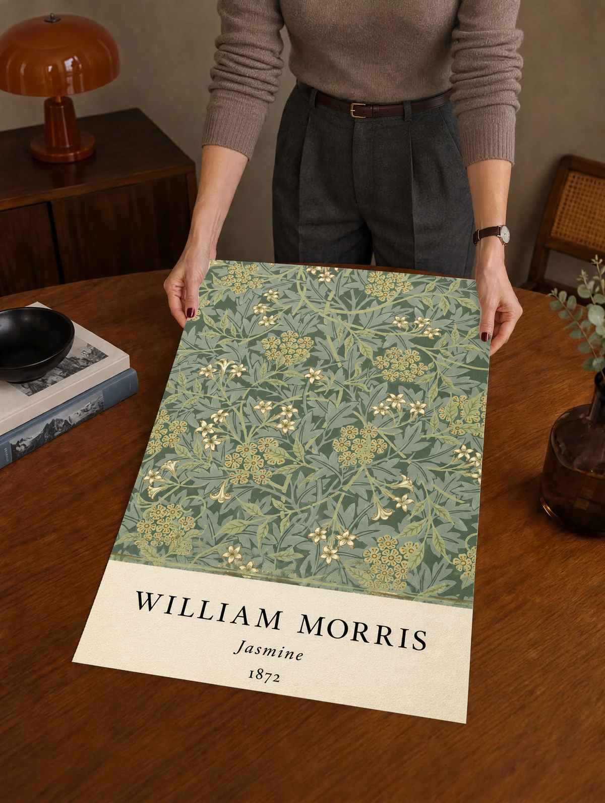 William Morris Jasmine sage and olive foliage with pale yellow flowers as an unframed print held over a wooden table beside a record player