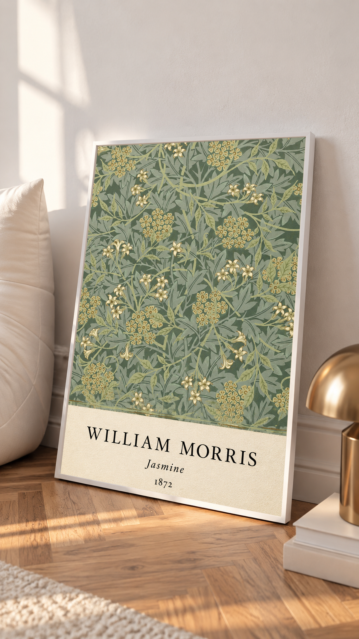 William Morris Jasmine sage and olive foliage with pale yellow flowers in a white frame leaning on a sunlit floor beside a brass lamp