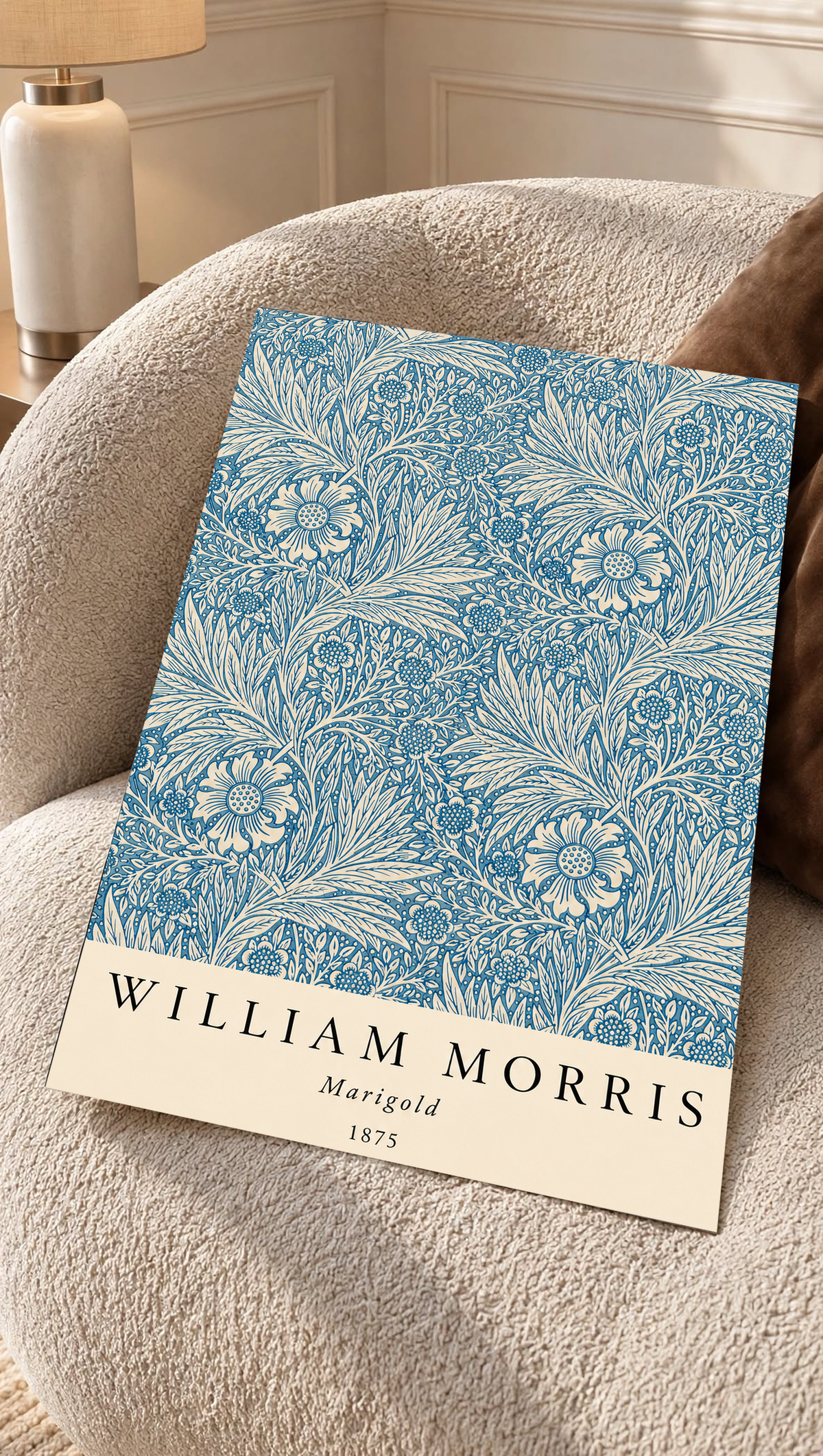 William Morris Marigold blue and cream floral leaf pattern as an unframed print resting on a boucle chair