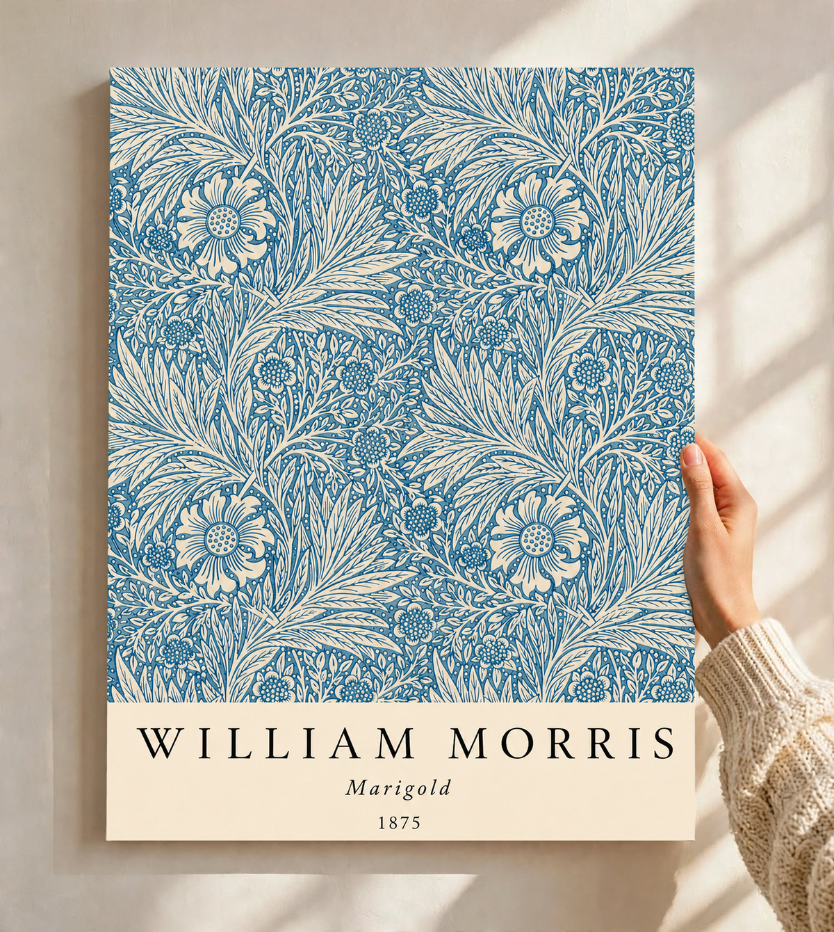 William Morris Marigold blue and cream floral leaf pattern as an unframed print held against a pale wall in a close view