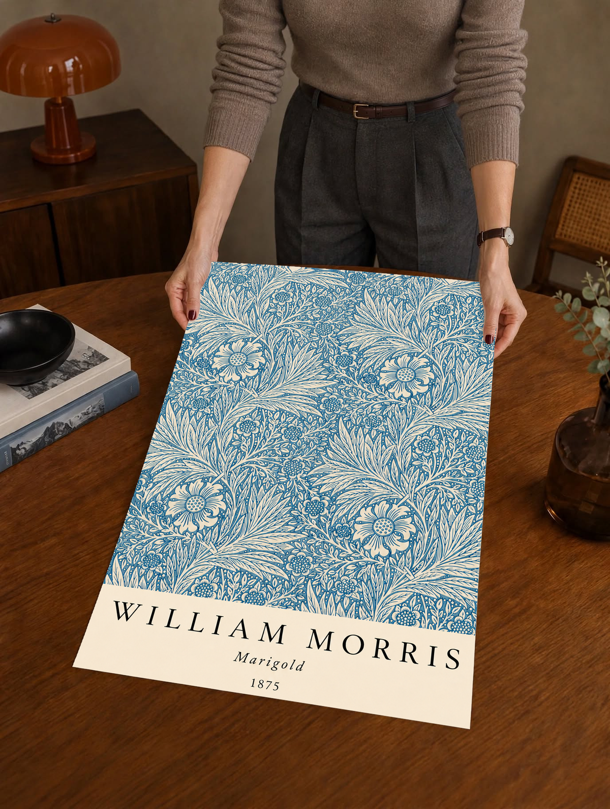 William Morris Marigold blue and cream floral leaf pattern as an unframed print held over a wooden table beside a record player
