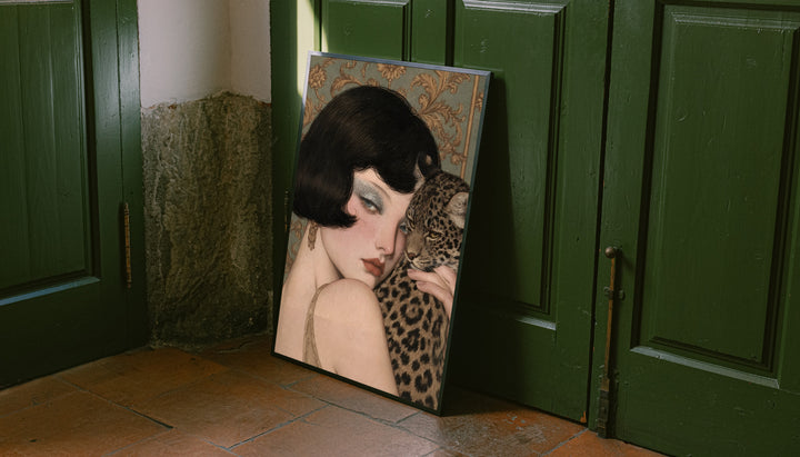 Portrait print with dark frame leaning against green doors of a pale woman and leopard