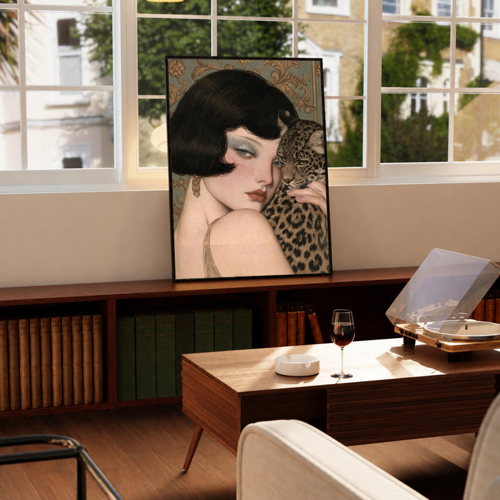 Portrait wall art in a light frame featuring a pale woman holding a leopard