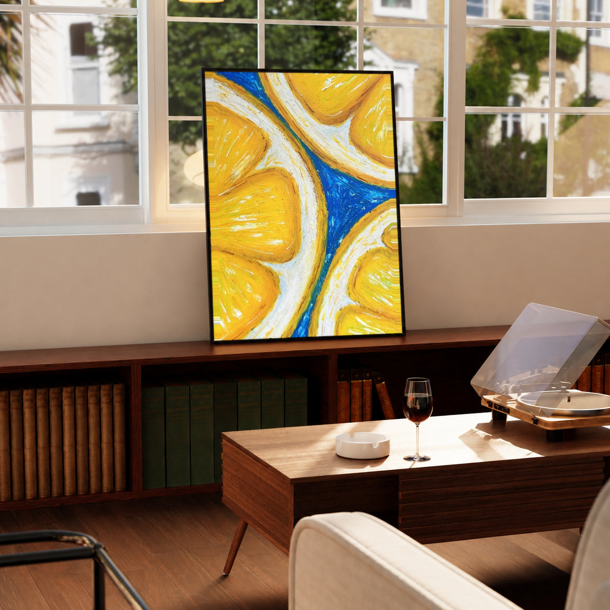 Oversized yellow lemon slices with white rinds against cobalt blue in a black display frame on a wooden console beside a sunlit window