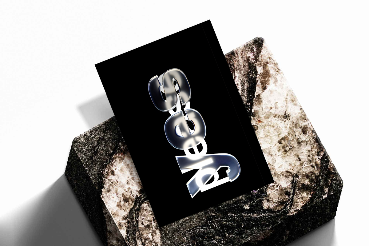 Yes Please lettering with reflective silver yes and overlapping white please on black, shown as an unframed print tilted on a dark stone display against a light background